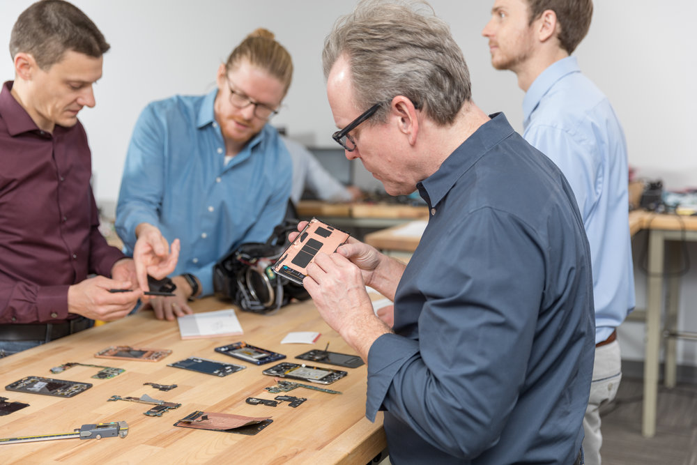 People working at workbench with circuit boards